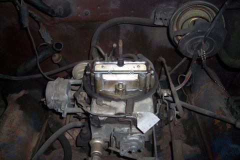 1978 Ford Bronco - A detailed view of a carburetor assembly with various hoses and wires connected.