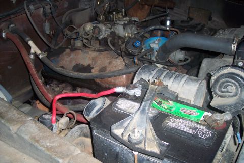 1978 Ford Bronco - Close-up view of a vehicle's engine bay, showing the battery and various engine components.