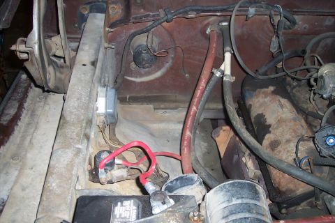 1978 Ford Bronco - Close-up view of the engine bay, showing the battery, various hoses, and electrical components.