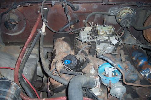 1978 Ford Bronco - Close-up view of an engine bay, focusing on the carburetor and distributor components.