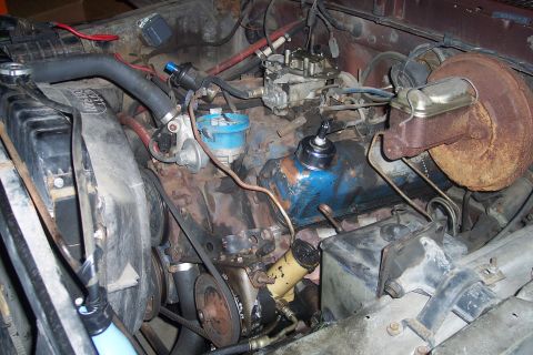 1978 Ford Bronco - Close-up view of the engine bay, showing the carburetor, brake booster, and various hoses and belts.