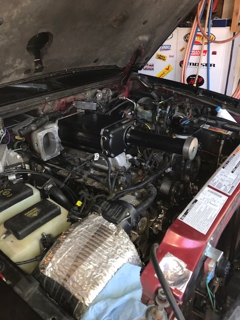 2000 Ford Explorer - Engine bay of a red SUV with a supercharger installed, viewed from above.