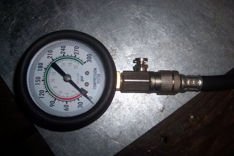 1995 Ford Bronco - A compression tester gauge is shown, indicating a reading of approximately 120 psi.