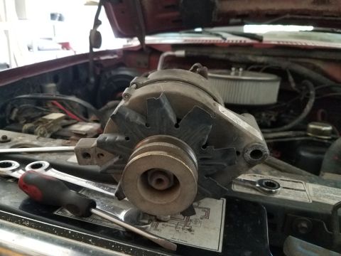 1985 Ford Bronco - Close-up of an alternator in a vehicle's engine bay, with tools nearby.