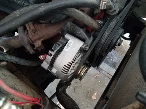 1985 Ford Bronco - Close-up of an alternator and drive belt system, likely in a vehicle engine bay.