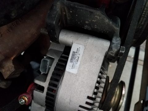 1985 Ford Bronco - Close-up of a vehicle alternator, showing a "Remanufactured in Mexico" label with part numbers and a date.