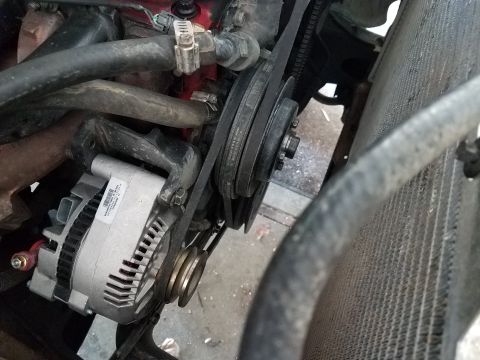 1985 Ford Bronco - Close-up view of an engine's alternator and belt drive system.