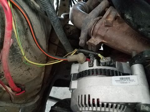 1985 Ford Bronco - Close-up view of an engine's alternator and surrounding components, with a remanufacturing label visible.