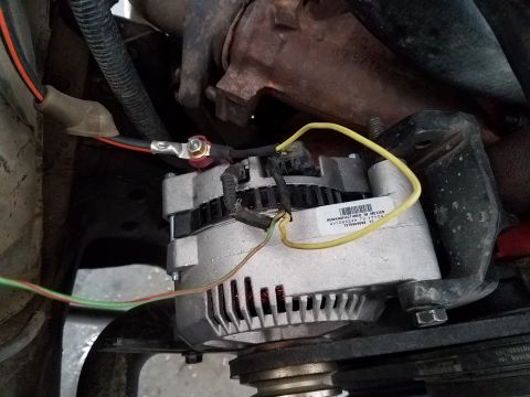 1985 Ford Bronco - Close-up view of an automotive alternator and its wiring.