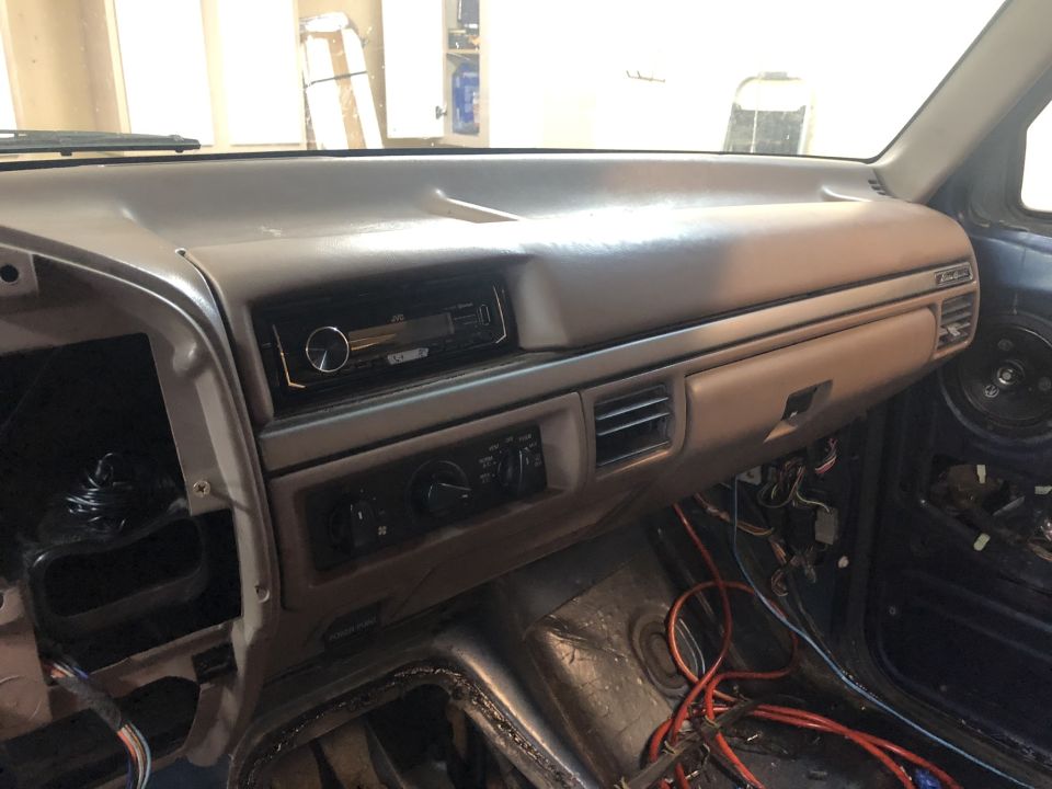 Gray dashboard with aftermarket stereo and exposed wiring. 1995 Ford Bronco