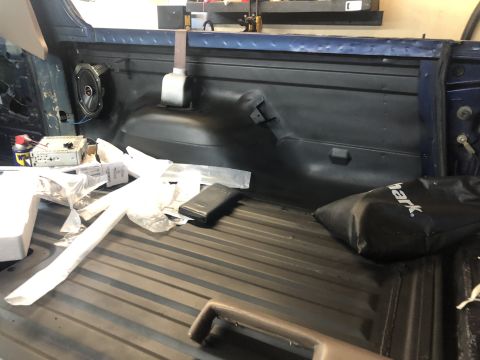 1995 Ford Bronco - Pickup truck bed interior with a speaker and items, possibly during a modification or after an installation.