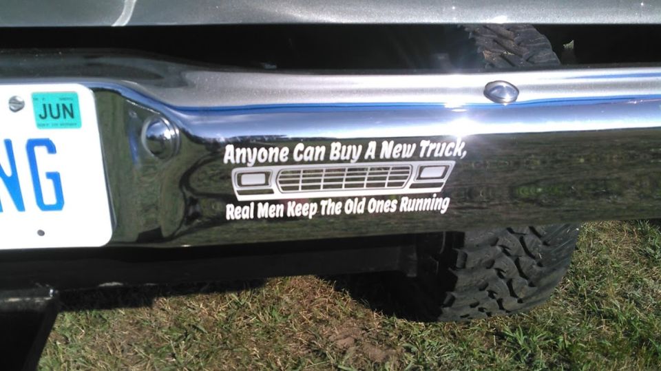 Chrome rear bumper with a sticker that says 'Anyone Can Buy A New Truck, Real Men Keep The Old Ones Running' and a license plate