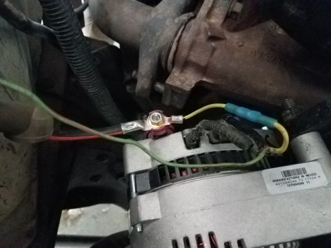 1985 Ford Bronco - Wiring connected to a vehicle's alternator, showing electrical connections and mechanical components.