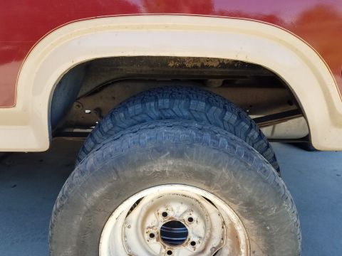 1985 Ford Bronco - Close-up of the rear wheel well and tires on a 1985 Ford Bronco.