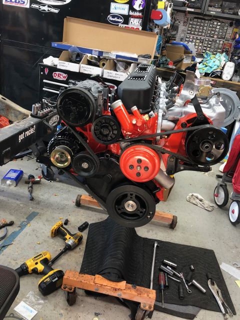 1992 Jeep Wrangler - Engine assembly is shown on a stand in a workshop setting with various tools nearby.