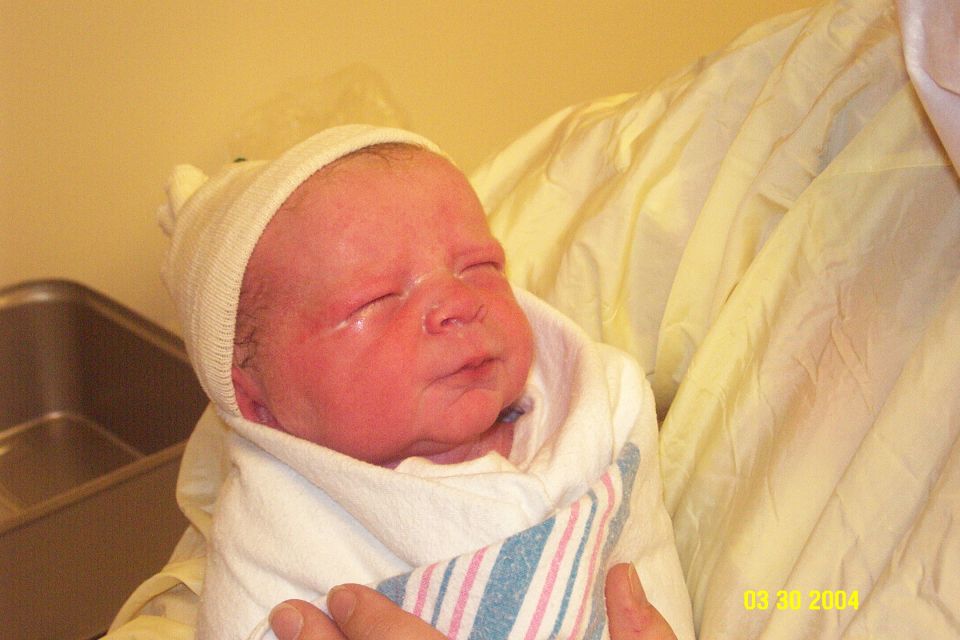 Newborn baby wrapped in a blanket and wearing a hat