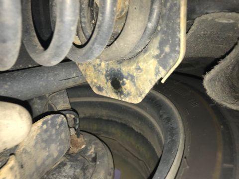 2008 Ford Focus - Undercarriage view of a vehicle's suspension system and tire, showing signs of wear and rust.