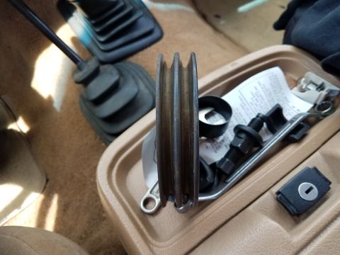 1985 Ford Bronco - A pulley and assorted parts are visible inside the vehicle's interior, near the gear shifter.