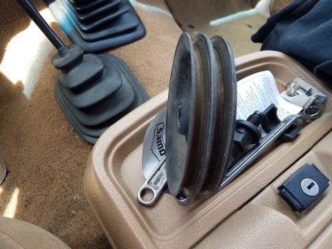 1985 Ford Bronco - Interior view of a vehicle's center console holding automotive parts and tools.