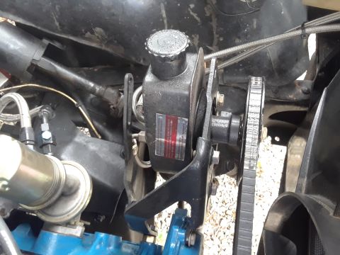 1985 Ford Bronco - Close-up of the power steering pump assembly in a 1985 Ford Bronco, showing the pulley and belt system.