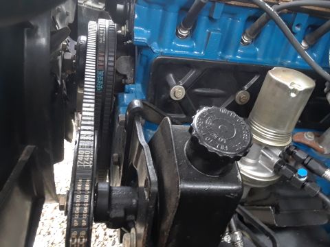 1985 Ford Bronco - Close-up view of engine components including a belt and power steering pump.