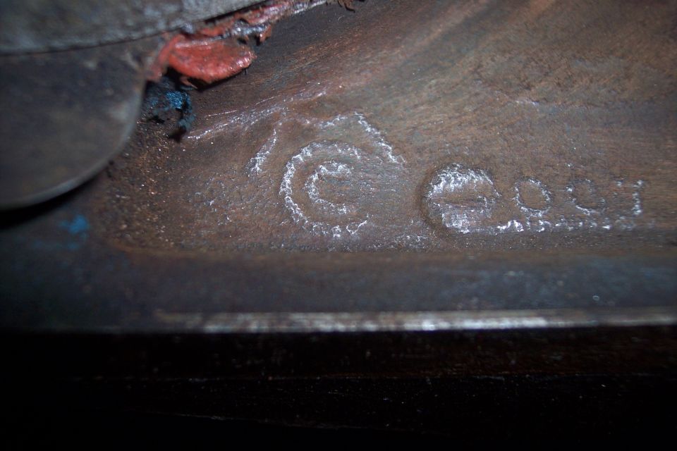 Close-up of cast metal part with circular symbol and numbers 'C 904'