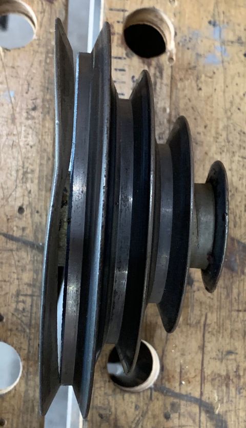 2002 Ford Ranger - A metal pulley with three grooves is shown on a wooden workbench.