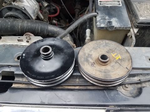 1985 Ford Bronco - Comparing a new pulley with an old, damaged one, likely for a vehicle repair.