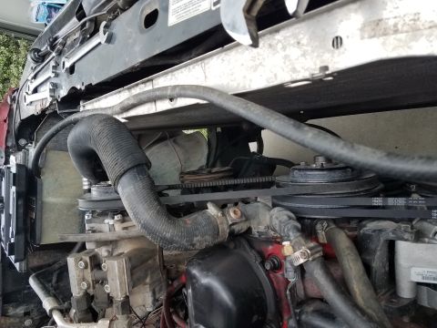1985 Ford Bronco - Close-up view of engine components, including hoses and belts, in a vehicle's engine bay.