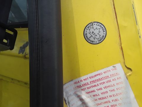 1994 Ford Bronco - Vehicle door jamb shows a Transport Canada sticker and a warning label about ambulance preparation.