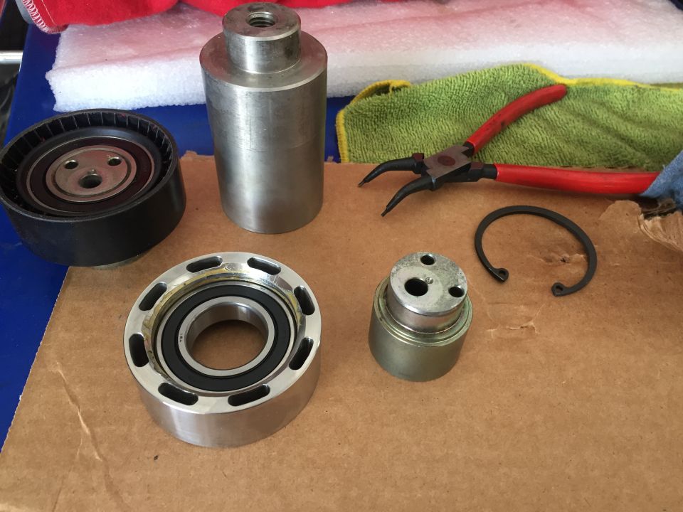 Pulley, bearing, and other metal parts laid out with snap ring pliers