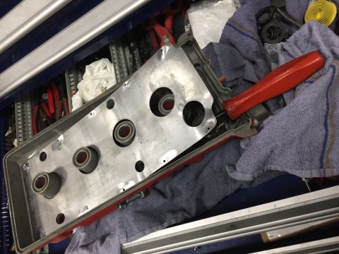2000 Lotus Esprit - A red gasket engine part lies on towels next to a red-handled tool, with other tools visible in the background.