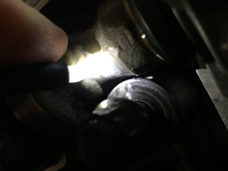 Engine part illuminated by flashlight. Supermotors.net logo visible