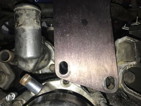 2000 Ford Explorer - Engine part detail, possibly a thermostat housing, with a metal plate attached.