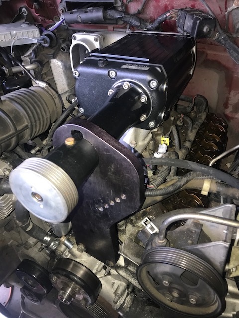 2000 Ford Explorer - Close-up view of a Kenne Bell supercharger being installed in a vehicle's engine bay.