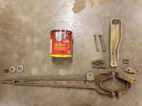1978 Ford Bronco - Various automotive parts and a can of rust preventative are arranged on a concrete surface.