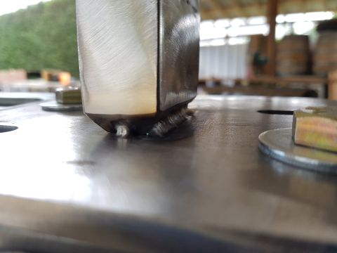 1978 Ford Bronco - A close-up view of a metal component, showing detailed welding work and fasteners. The background is out of focus.