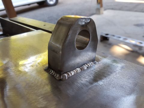 1978 Ford Bronco - A metal bracket with a hole has been welded onto a flat surface.