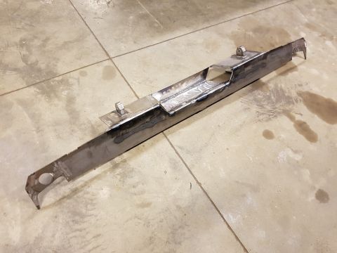 1978 Ford Bronco - A custom metal part, likely a frame component, is shown on a workshop floor.