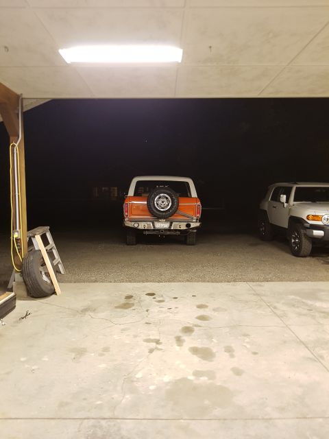 1978 Ford Bronco - Rear view of an orange 1978 Ford Bronco and a white Toyota FJ Cruiser in a garage.