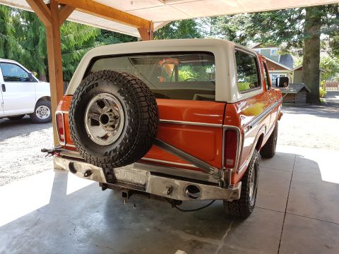 1978 Ford Bronco - This 1978 Ford Bronco is parked under a covered area next to a white van.