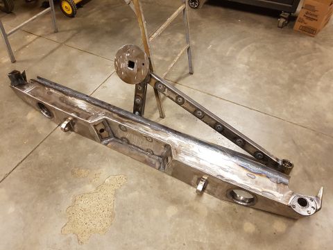 1978 Ford Bronco - A custom fabricated steel bumper and spare tire carrier assembly is shown in a workshop setting.