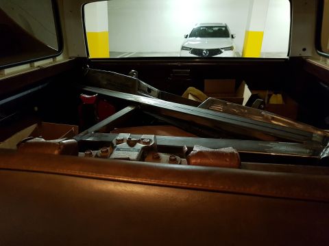 1978 Ford Bronco - Parts are loaded in the back of a vehicle, with another car visible in the background.