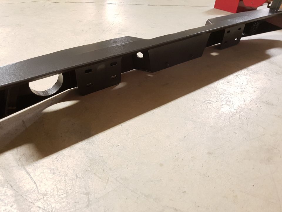 Black metal frame with mounting brackets and a circular cutout, viewed from an angle