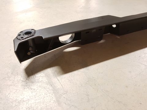 1978 Ford Bronco - A dark metal suspension part is shown in detail, resting on a concrete floor.