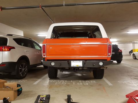 1978 Ford Bronco - The rear of an orange and white 1978 Ford Bronco is visible in a parking garage.