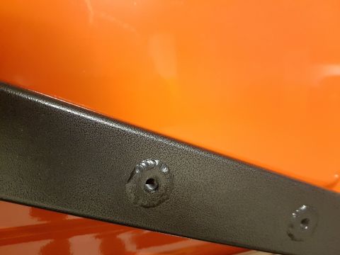 1978 Ford Bronco - Close-up of a black metal bracket bolted to an orange surface, with Supermotors.net watermark.