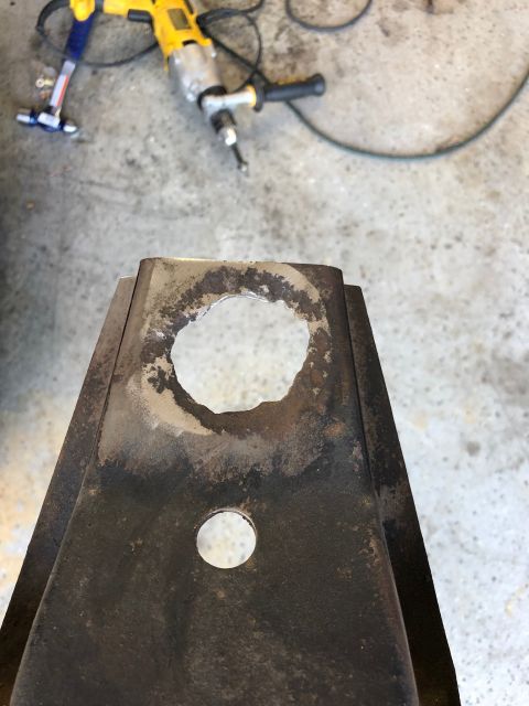 1992 Jeep Wrangler - A metal frame component shows a large, rough hole that has been drilled into it, with a smaller hole below.