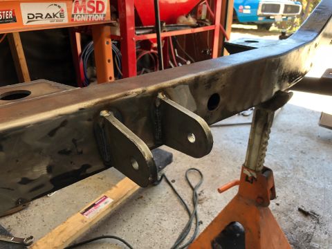 1992 Jeep Wrangler - A vehicle frame, likely from an off-road vehicle, is supported by orange jack stands in a workshop setting.