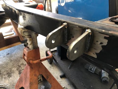 1992 Jeep Wrangler - Close-up of a welded frame section on jack stands, with a welding machine visible in the background.